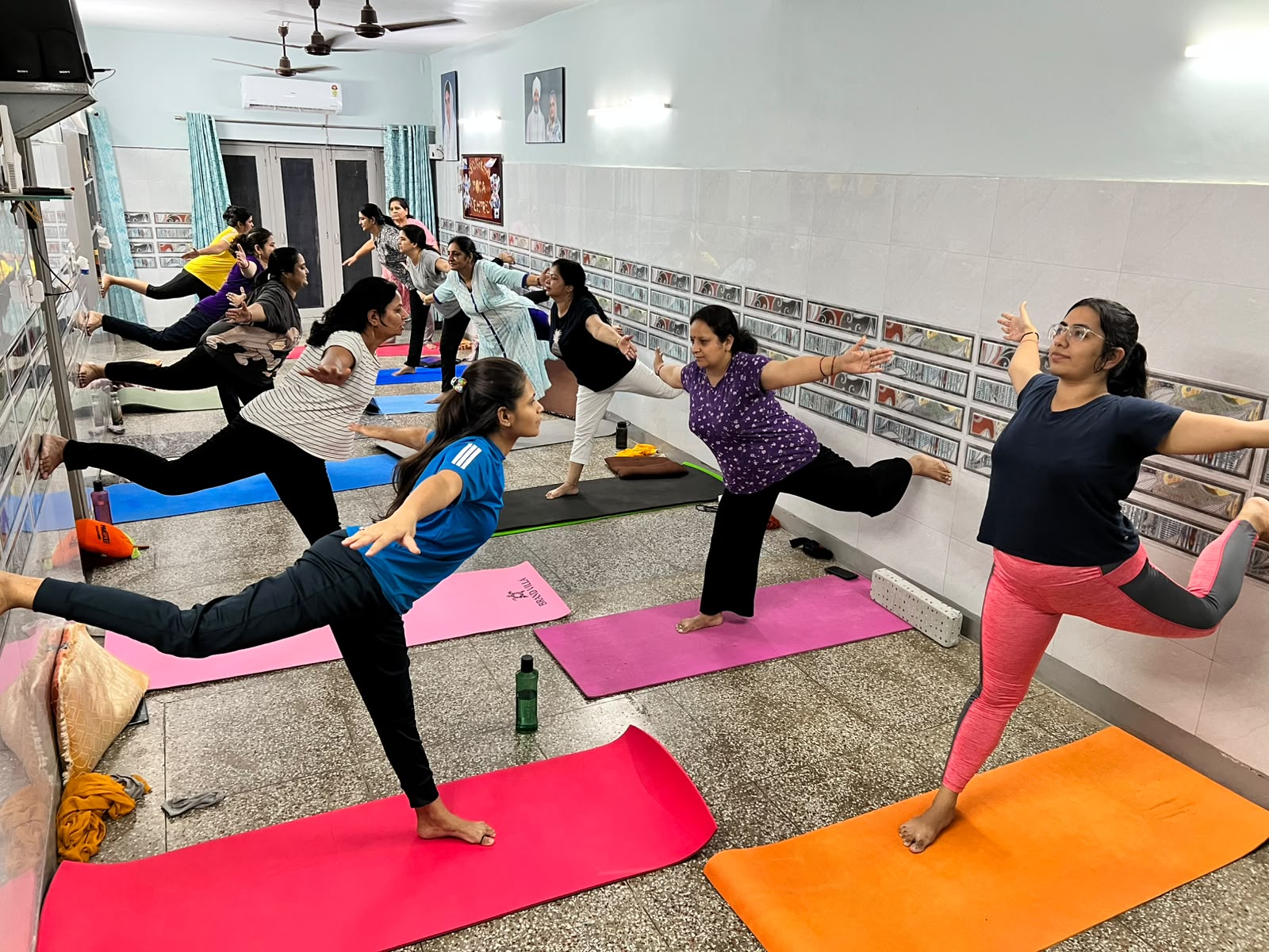 Interactive group yoga class with multiple students practising together at Nirankari Yoga Centre, Gurugram